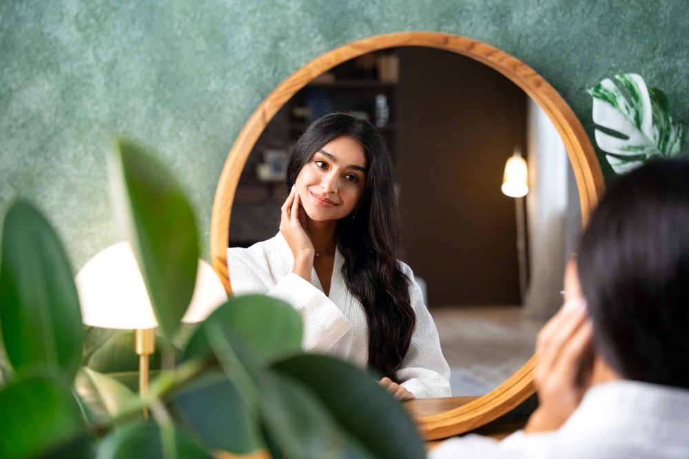 Woman checking facial appearance before Botox consultation in a professional cosmetic clinic setting