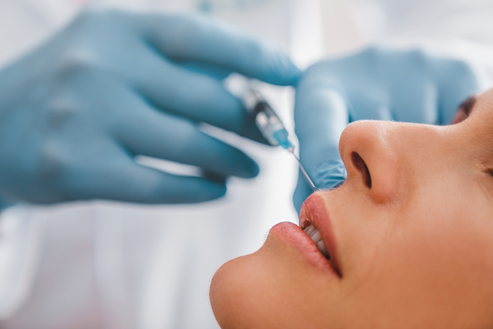 Medical professional performing a facial filler injection procedure in a clinical setting