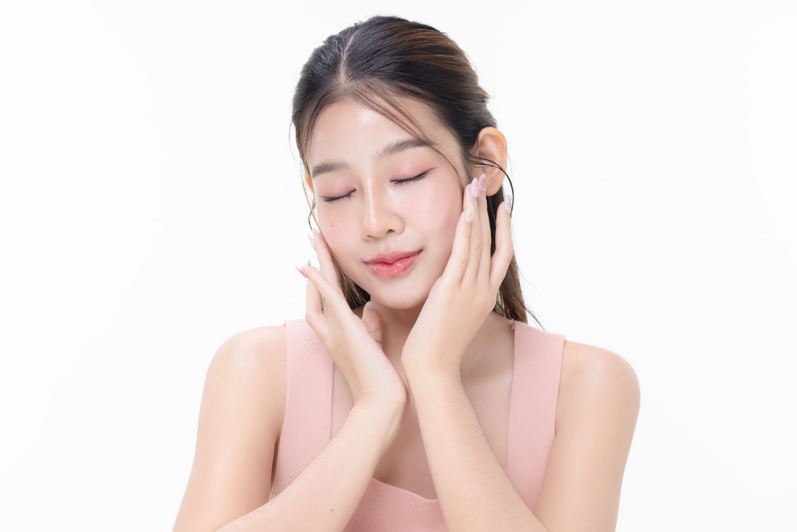 Woman with healthy, glowing skin gently touching her face after aesthetic treatment, showing a refreshed and radiant complexion.